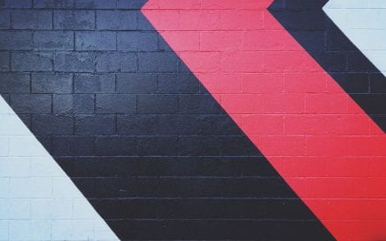 Black and red abstract lines painted on a gray brick wall